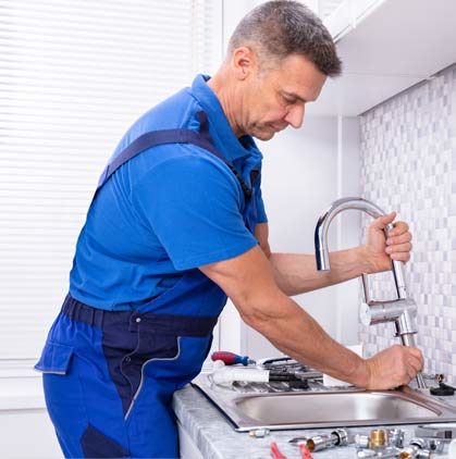 Stock image of a person repairing in kitchen