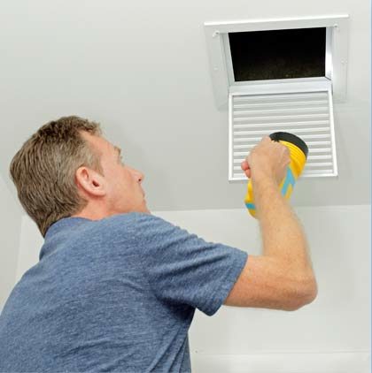 Stock image of a person cleaning air duct