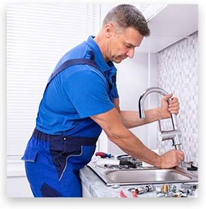 Stock image of a person repairing in kitchen