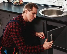 Stock image of a person doing repair in kitchen